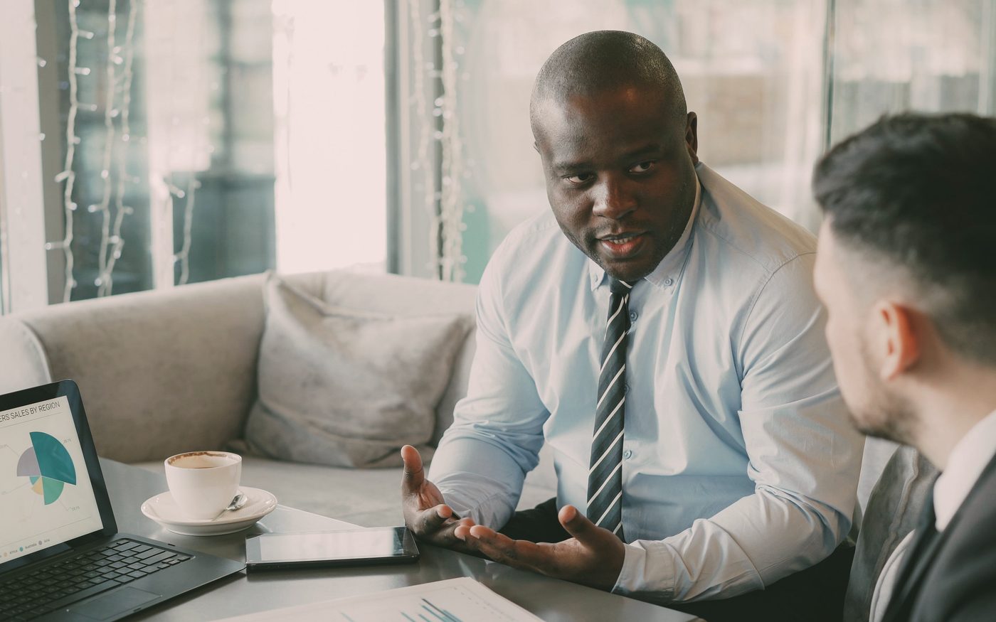 An advisor walking a client through performance charts across the table